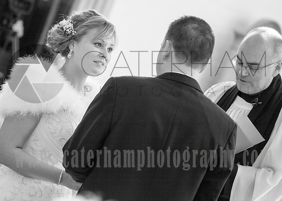 Romantice wedding -Surrey wedding photographer/ Bride and groom with the priest in the church during the ceremony - Black and White Photography