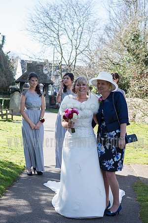 Surrey wedding photographer / St Johns Church Coulsdon Wedding / The bride hugging mum with bridesmaids in the background