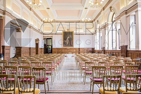 surrey wedding photographer- kingston county hall- bride and groom walking down chairs- ceremony room