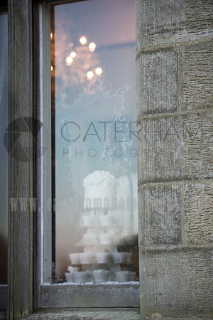 Surrey wedding photographer- Chiddingstone Castle- looking through window at cakes