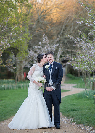 Surrey wedding photographer- Chiddingstone Castle- bride groom kissing and trees